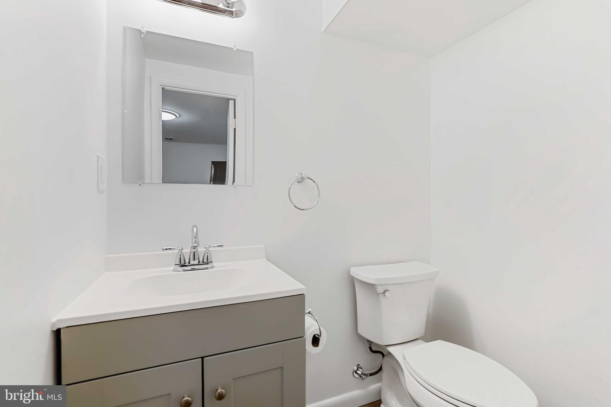 1634 Mt Airy Court Crofton, MD 21114 - Photo 30 of 40 a bathroom with a toilet sink vanity and mirror