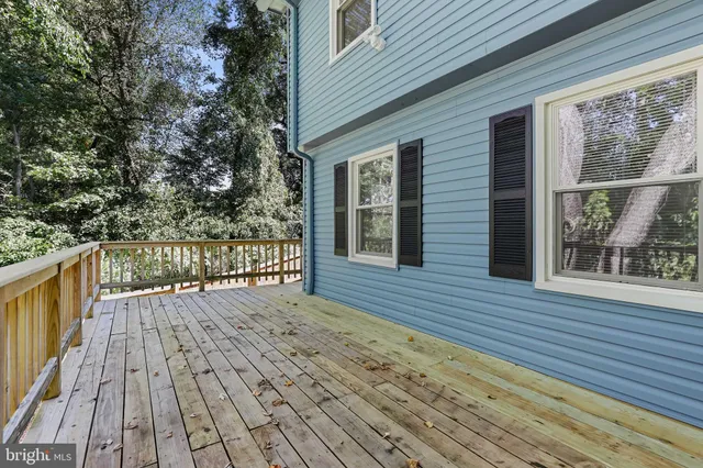 a view of deck with wooden floor and fence next to a yard