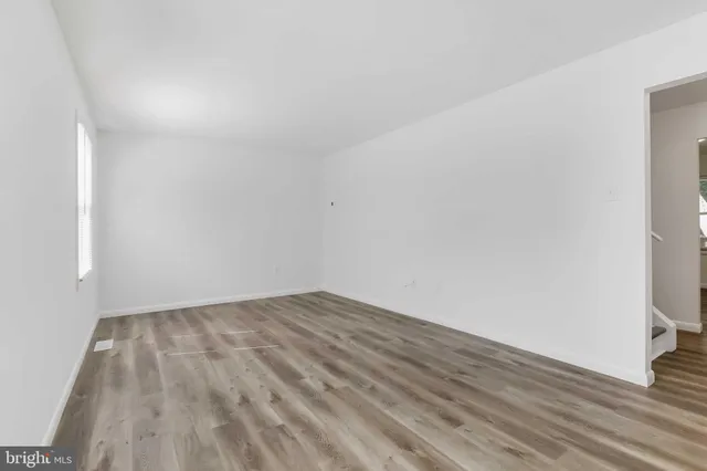 a view of an empty room with wooden floor
