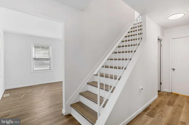 a view of staircase with wooden floor and white walls