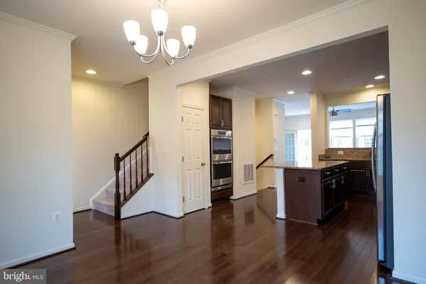 a view of a kitchen with a sink a refrigerator and wooden floor