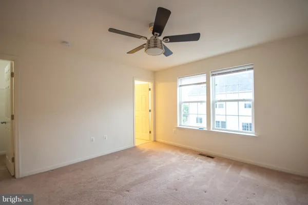 an empty room with a window and a fan
