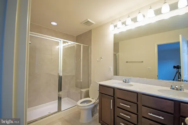 a bathroom with a granite countertop sink a toilet and shower