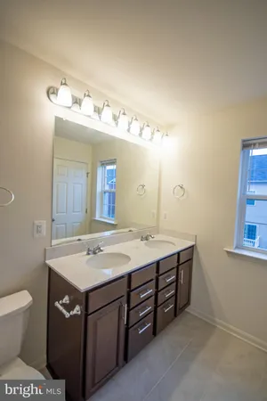 a bathroom with a sink a toilet and a mirror