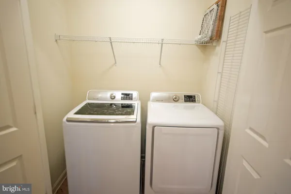 an empty room with windows and chandelier fan