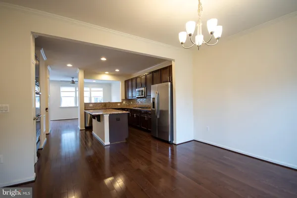 a view of kitchen with refrigerator and wooden floor
