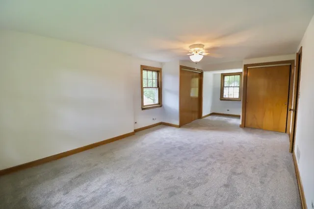 an empty room with windows and closet