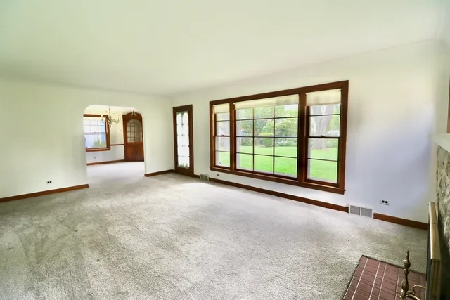 a view of a big room with windows and chandelier fan