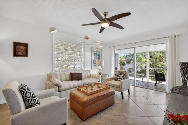 a living room with furniture a flat screen tv and a window