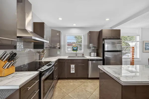 a kitchen with stainless steel appliances granite countertop a sink stove and refrigerator
