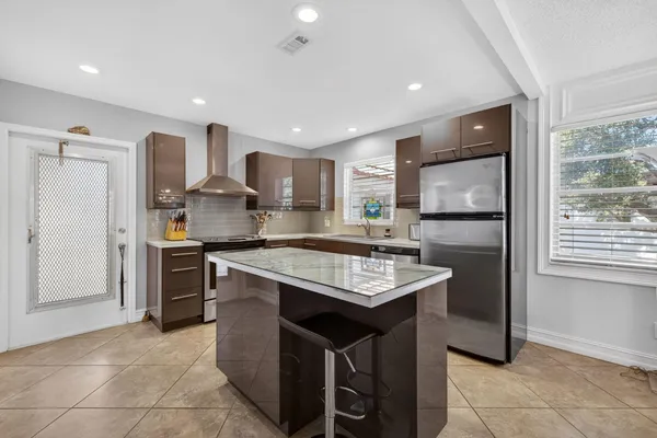 a kitchen with stainless steel appliances granite countertop a sink a stove and a refrigerator