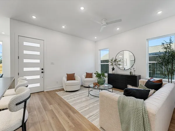 a living room with furniture kitchen and a potted plant
