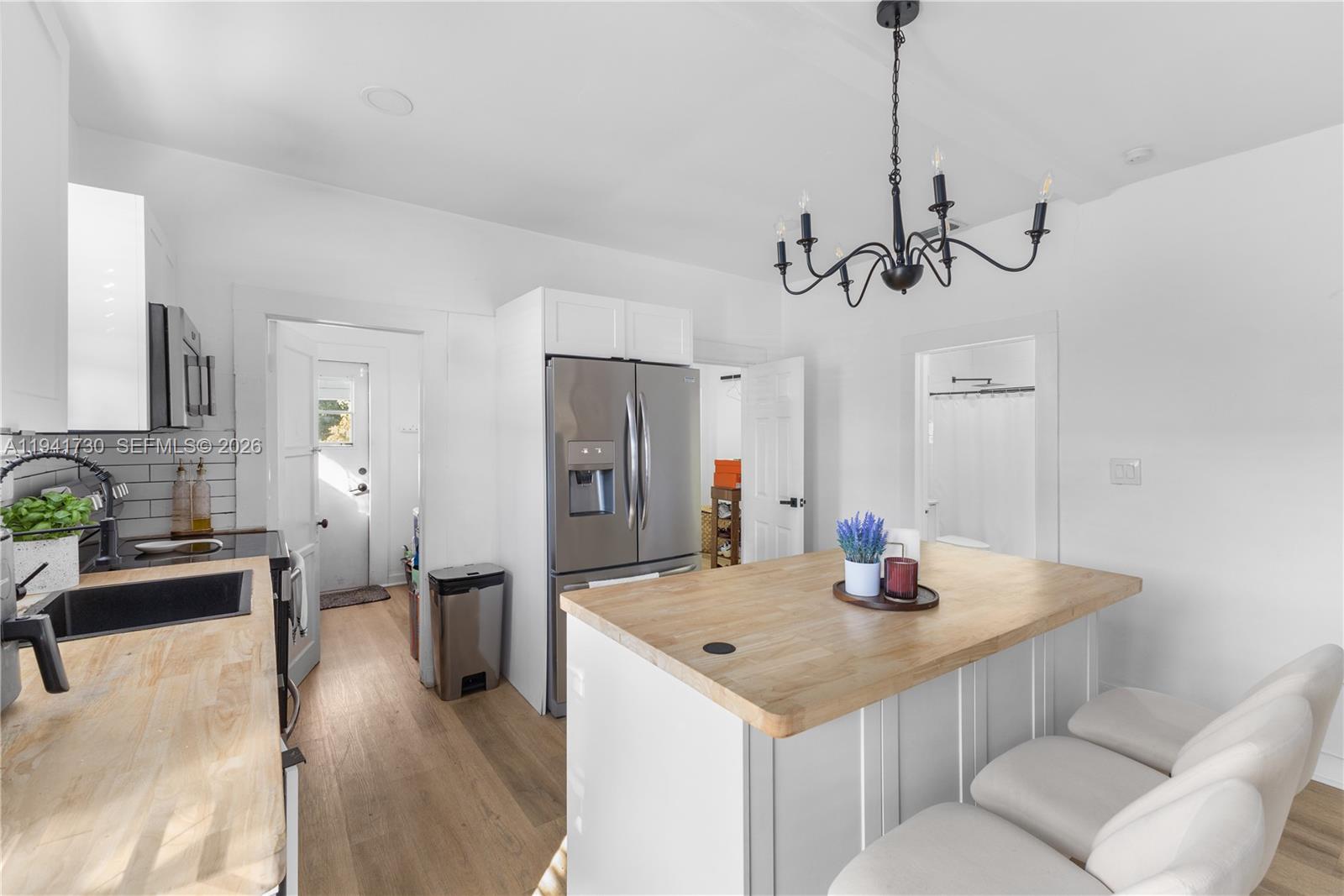 2811 Southwest 17th Street Miami, FL 33145 - Photo 12 of 36 a kitchen with stainless steel appliances kitchen island granite countertop a sink a refrigerator and chairs