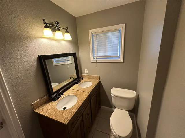 a bathroom with a toilet sink and mirror