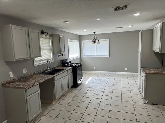 a kitchen with a sink a counter top space cabinets and stainless steel appliances