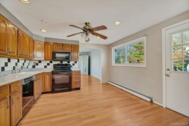 a kitchen with a refrigerator a stove top oven a sink and cabinets