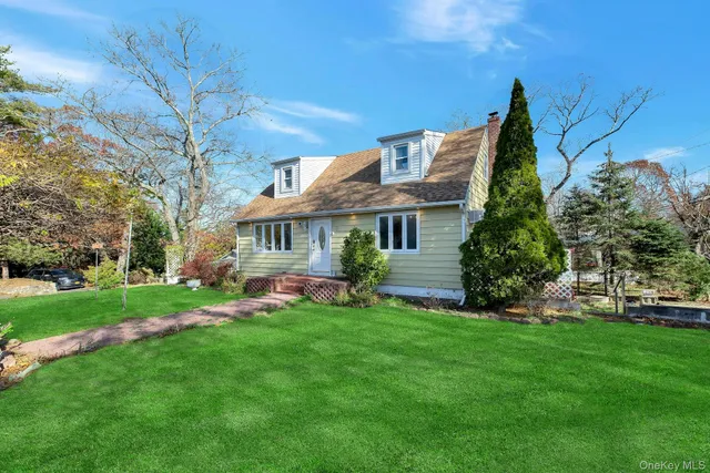 a front view of a house with a garden and trees