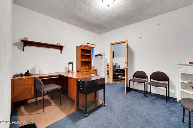 a view of a workspace with furniture and window