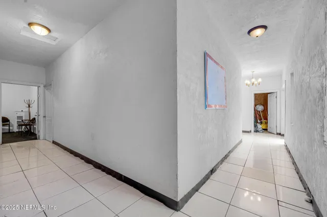 a view of a hallway with closet and a window
