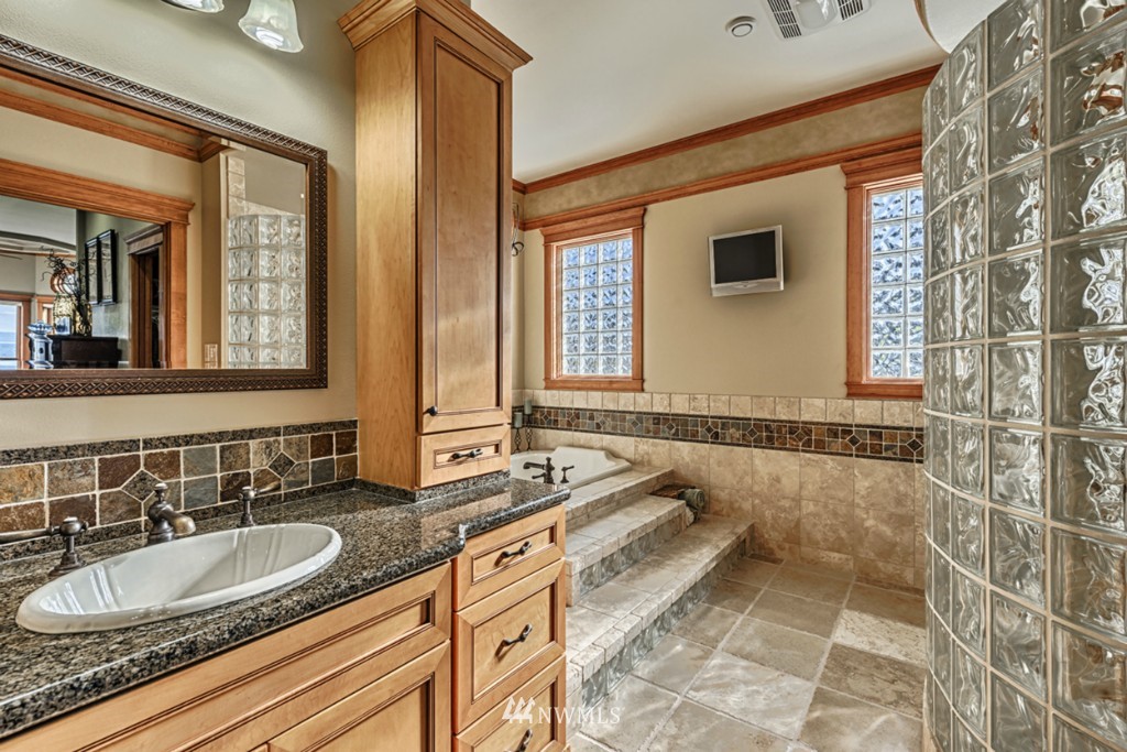 9690 Samish Island Road Bow, WA 98232 - Photo 12 of 25 a bathroom with a granite countertop tub a sink and a mirror