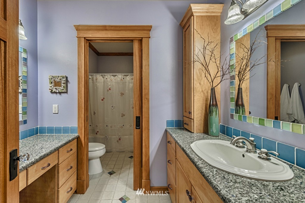 9690 Samish Island Road Bow, WA 98232 - Photo 14 of 25 a bathroom with a granite countertop sink a mirror and a shower