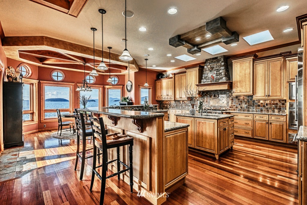 9690 Samish Island Road Bow, WA 98232 - Photo 7 of 25 a kitchen with stainless steel appliances kitchen island granite countertop a stove a sink and a refrigerator