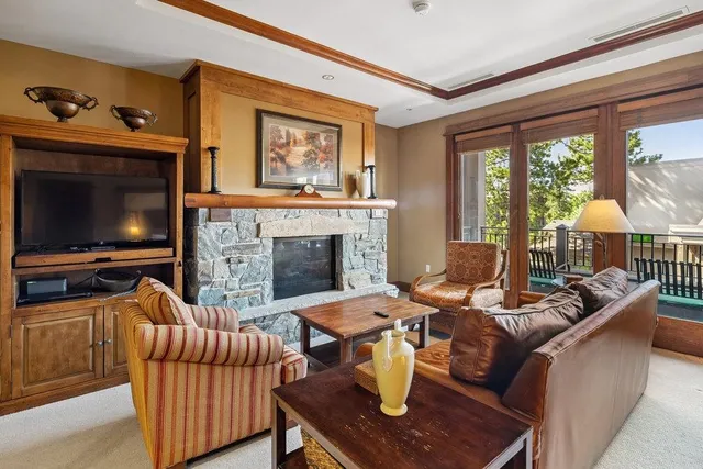 a living room with furniture a flat screen tv and a fireplace