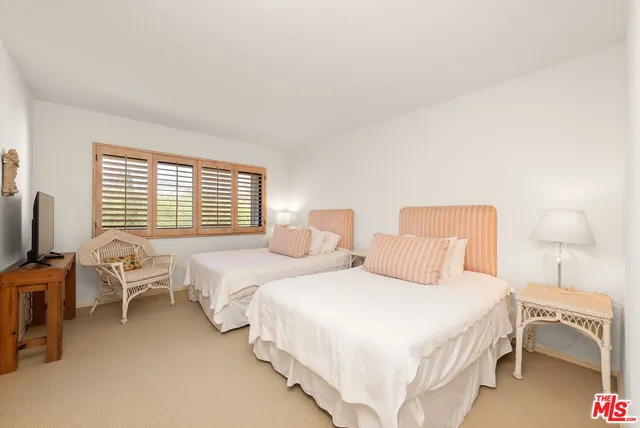 a bedroom with two beds and a chair