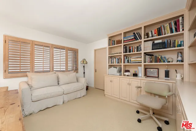 a living room with furniture and a book shelf