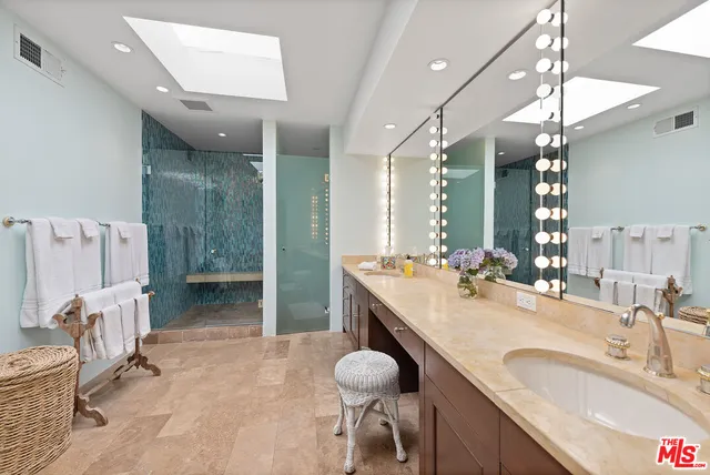 a bathroom with a granite countertop sink a toilet and a mirror