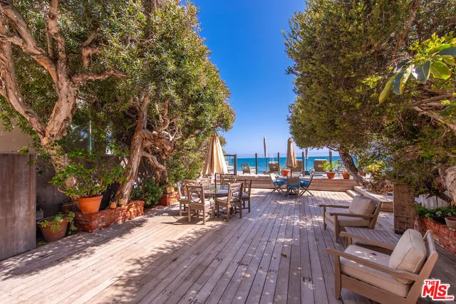 a view of a patio with table and chairs a barbeque with wooden fence and floor