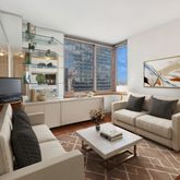 a living room with furniture a rug and a table