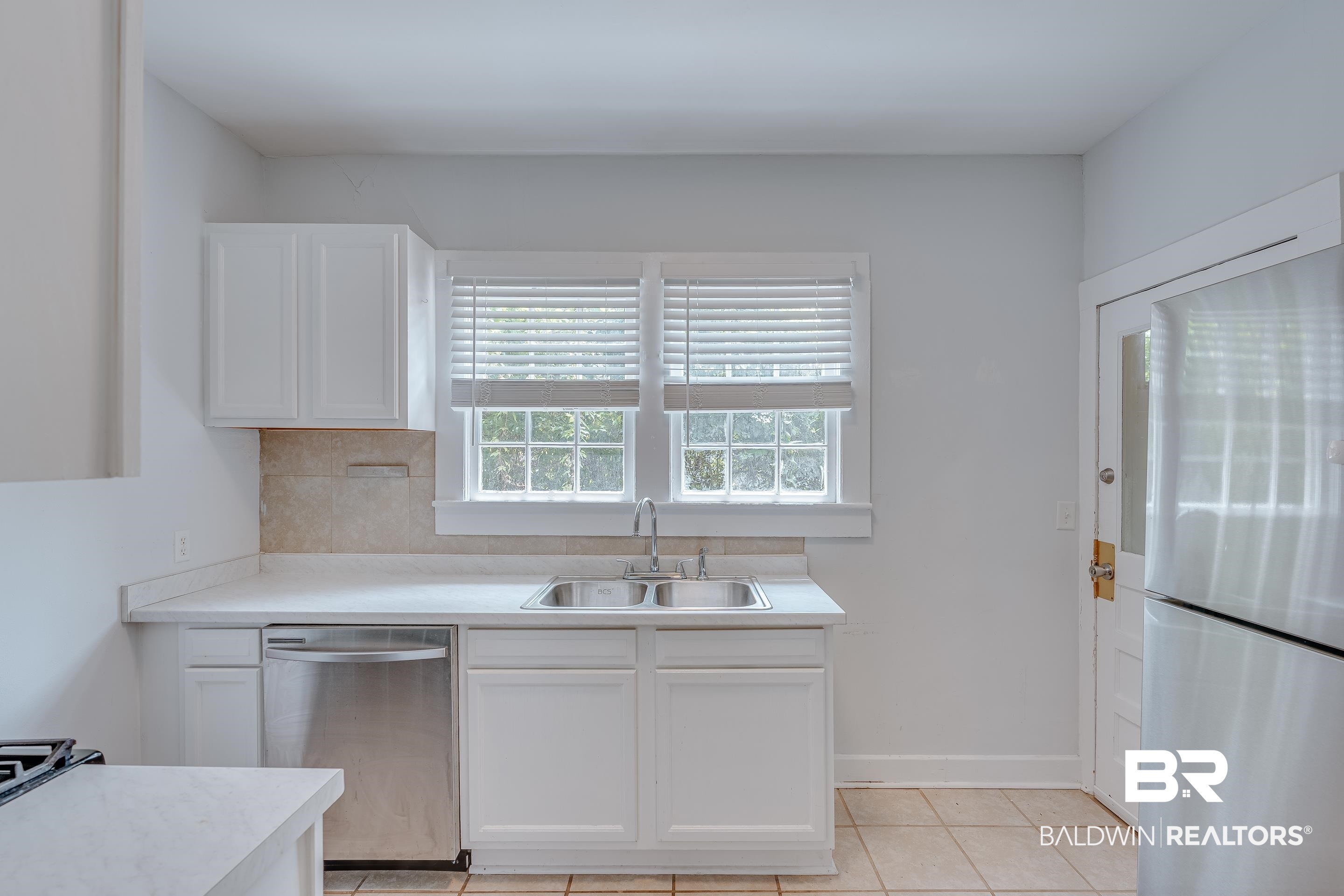 1852 Old Shell Road Mobile, AL 36607 - Photo 8 of 26 Kitchen with stainless steel appliances, white cabinets, light tile patterned floors, and light countertops