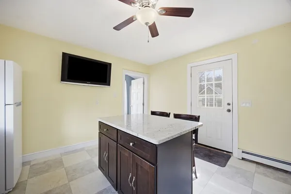 a kitchen that has a microwave a sink and a stove with wooden floor