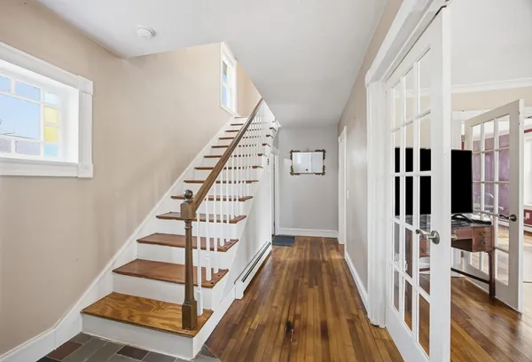 a view of staircase with lots of frames on wall and wooden floor