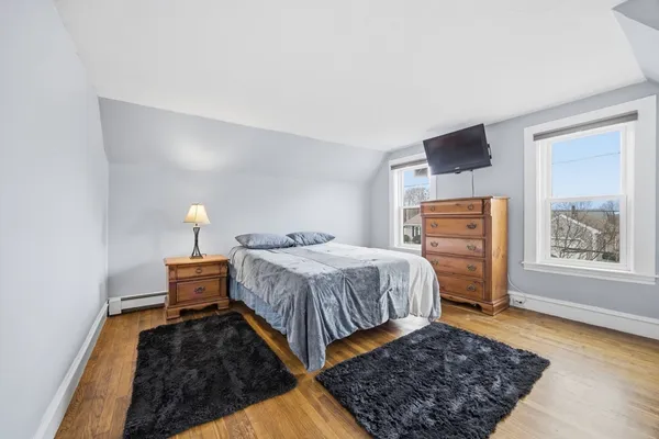 a bedroom with bed and wooden floor