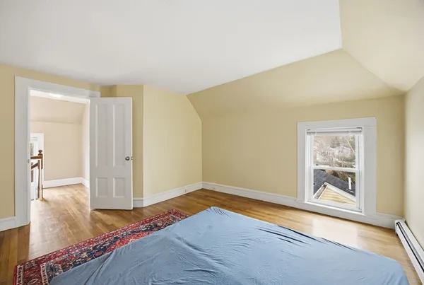 a bedroom with a bed and painting on the wall