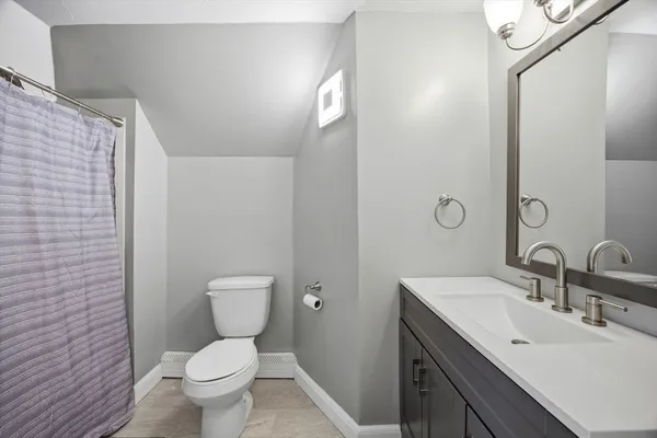 a bathroom with a toilet sink vanity and mirror