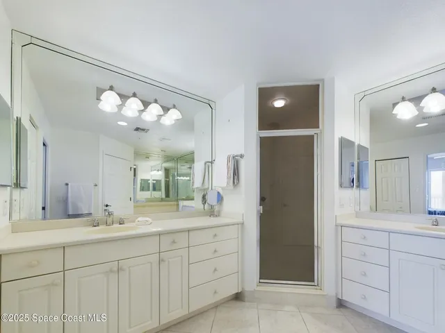 a spacious bathroom with a granite countertop sink a mirror and a shower