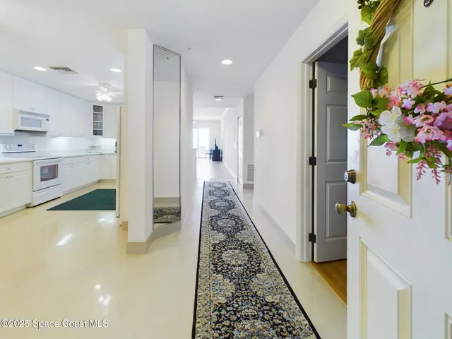 a view of a hallway to a dining room with chandelier