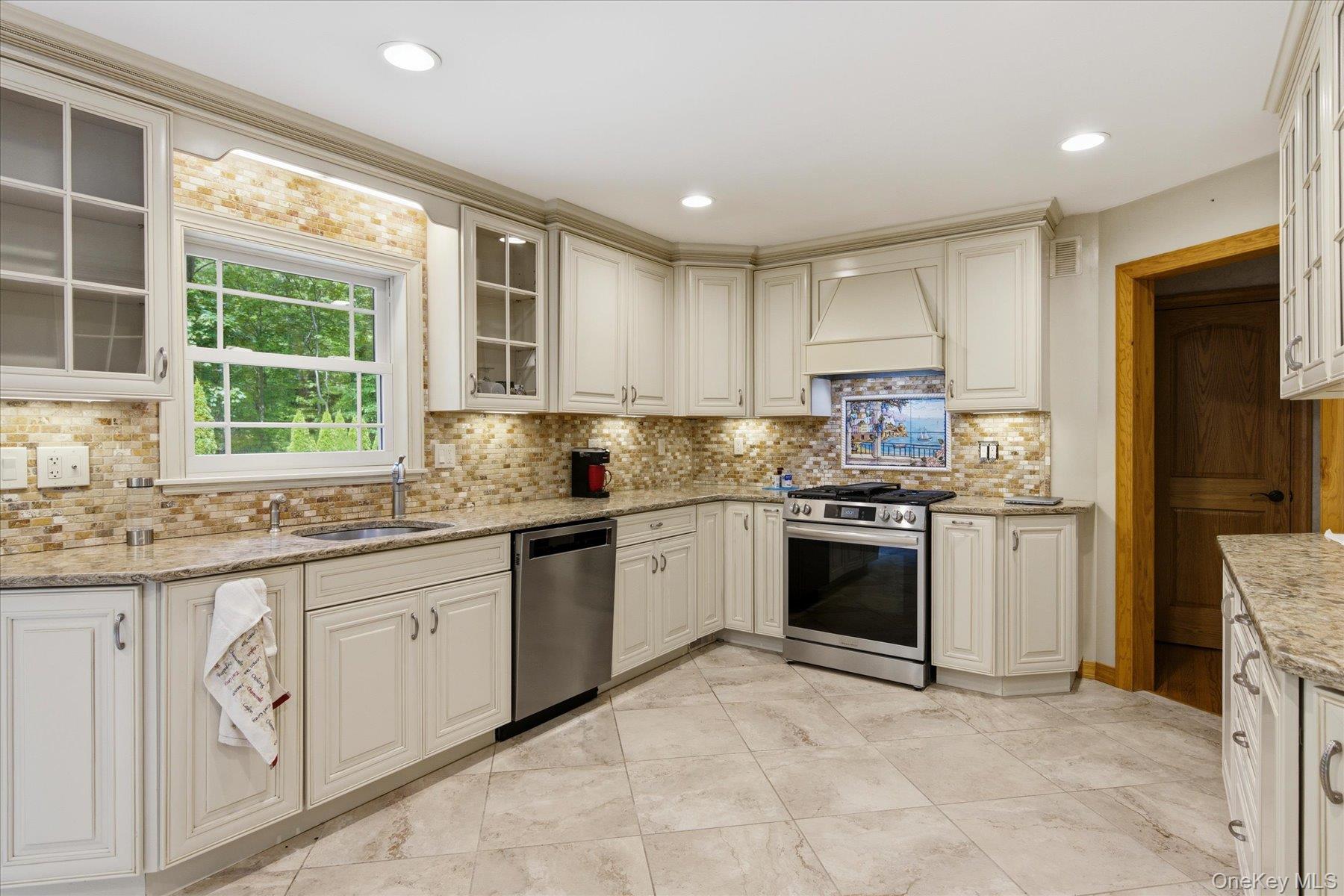 42 Cliff Road Port Jefferson, NY 11777 - Photo 12 of 22 a kitchen with granite countertop white cabinets a sink a window and stainless steel appliances