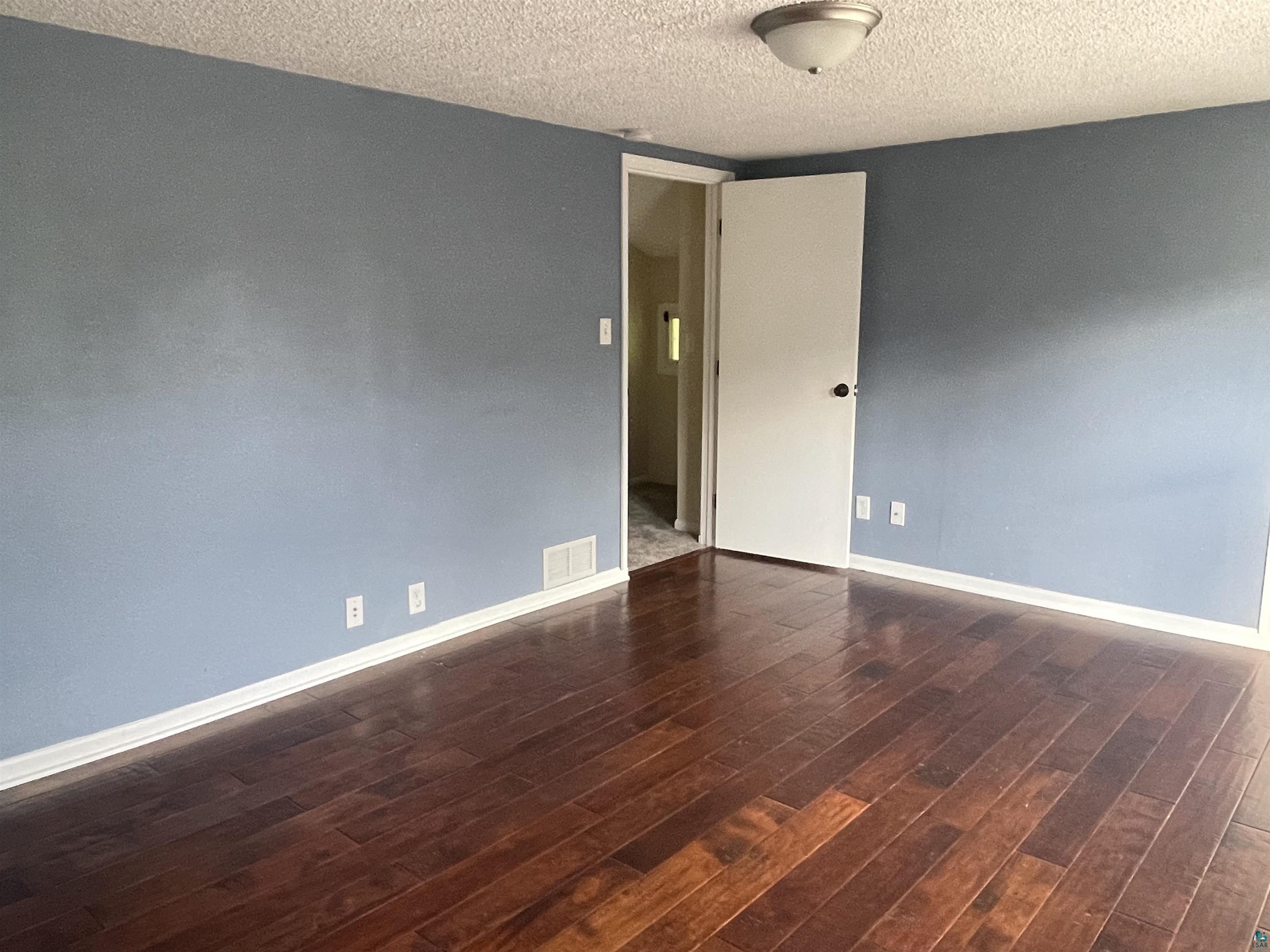 4315 Pitt Street Duluth, MN 55804 - Photo 22 of 27 Unfurnished room featuring a textured ceiling and dark wood-type flooring