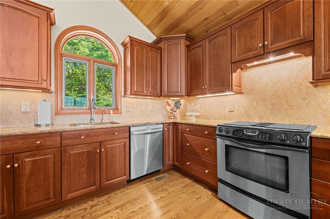 331 Alpine Road Blowing Rock, NC 28605 - Photo 21 of 50 a kitchen with stainless steel appliances granite countertop a stove a sink and a window
