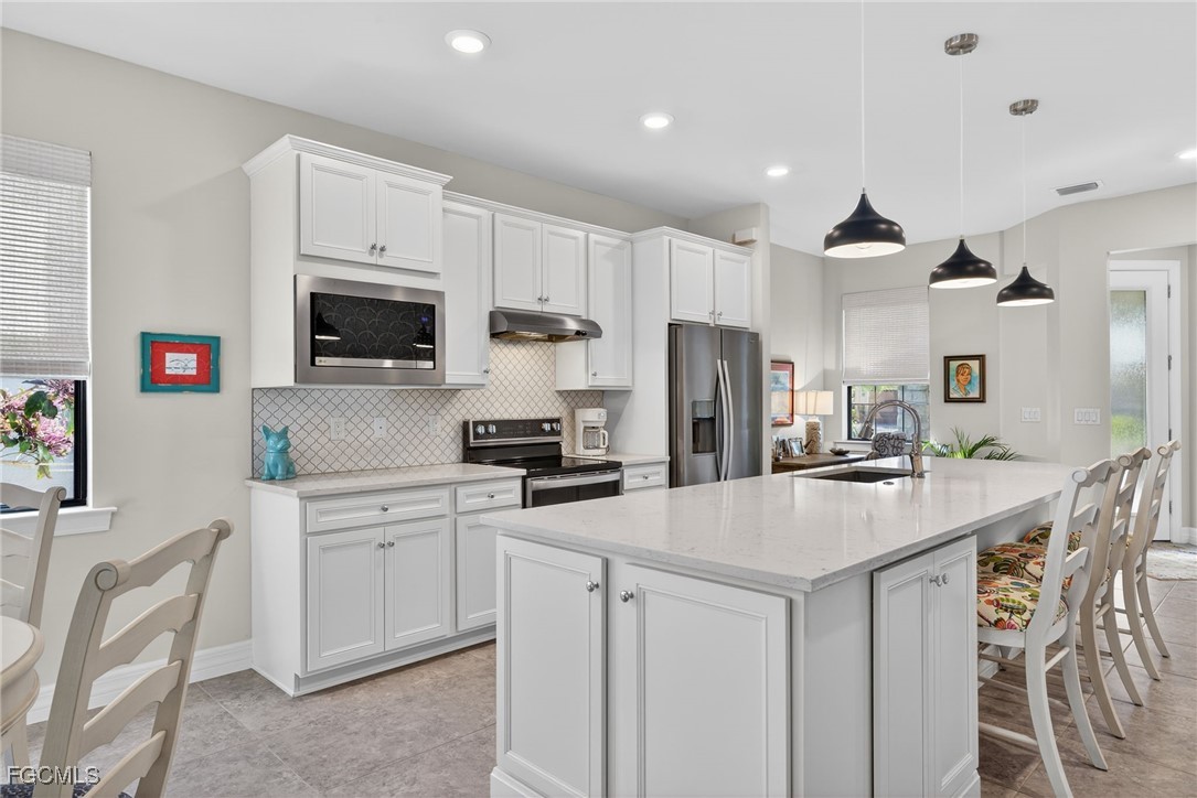 11268 Carlingford Road Fort Myers, FL 33913 - Photo 5 of 48 a kitchen with kitchen island a sink stove and refrigerator