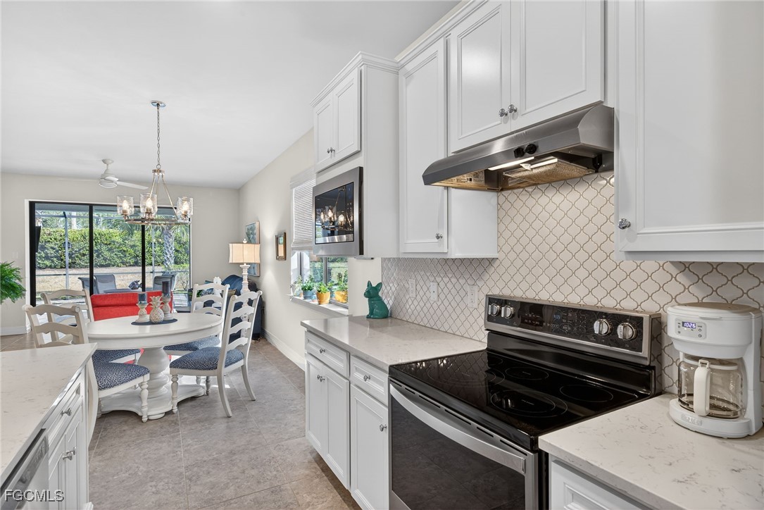 11268 Carlingford Road Fort Myers, FL 33913 - Photo 6 of 48 a kitchen with a stove a sink and chairs