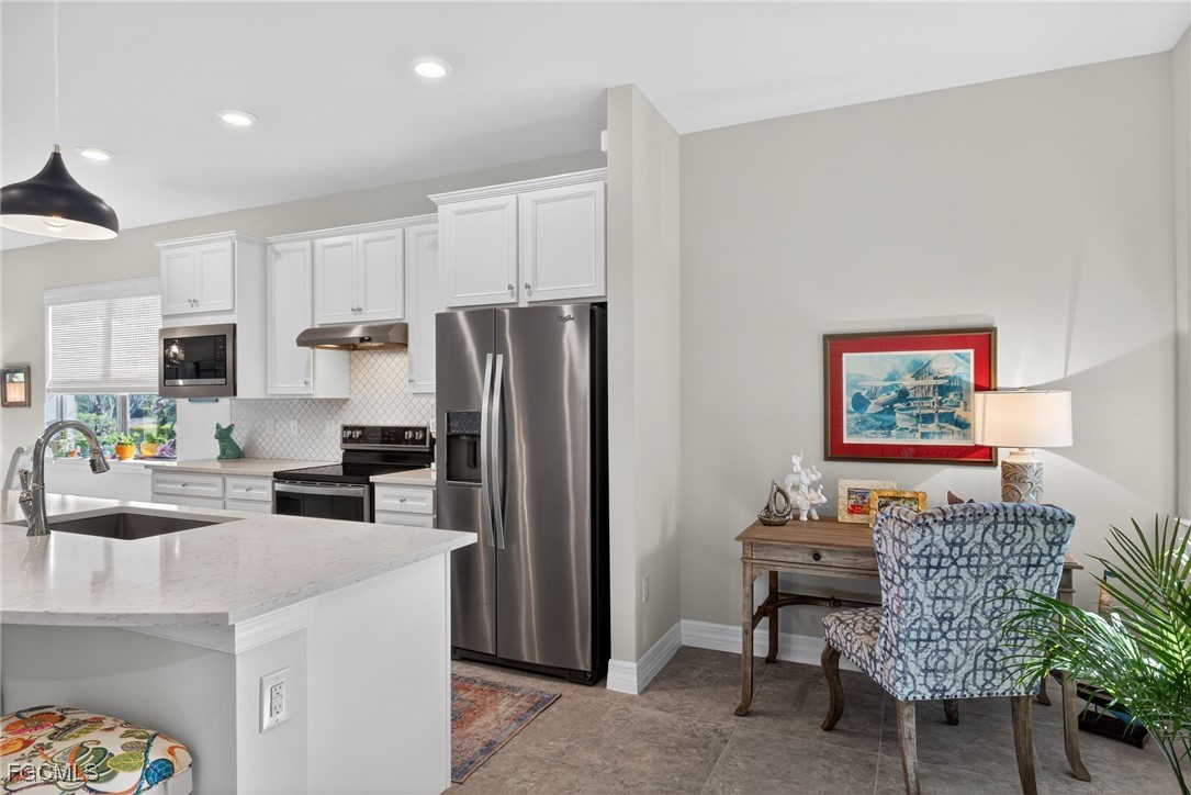 11268 Carlingford Road Fort Myers, FL 33913 - Photo 7 of 48 a kitchen with stainless steel appliances kitchen island granite countertop a refrigerator and a stove top oven