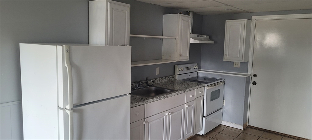 479 SOUTH Taunton Ma, Unit 1 Taunton, MA 02780 - Photo 5 of 5 a kitchen with a refrigerator and cabinets