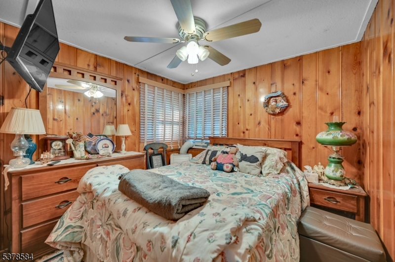 134 Birch Road Vernon, NJ 07422 - Photo 11 of 49 a bedroom with a large bed and a chandelier