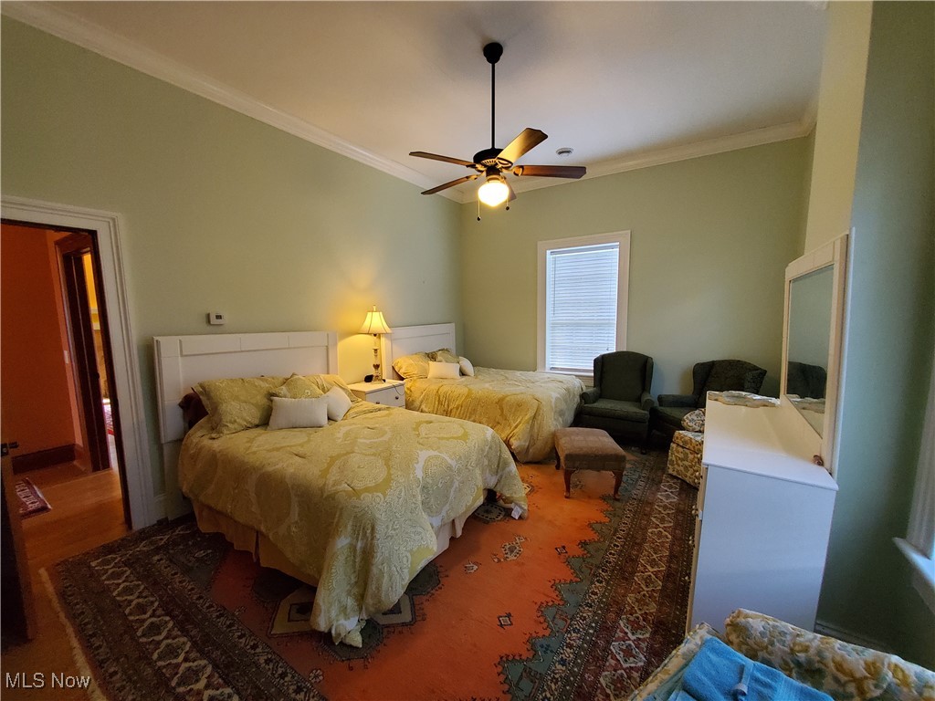 150 Main Street Hayesville, OH 44805 - Photo 33 of 50 Bedroom featuring ornamental molding, ceiling fan, and wood finished floors.