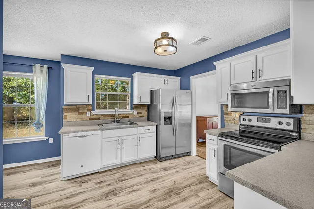 a kitchen with stainless steel appliances a stove a sink and a refrigerator